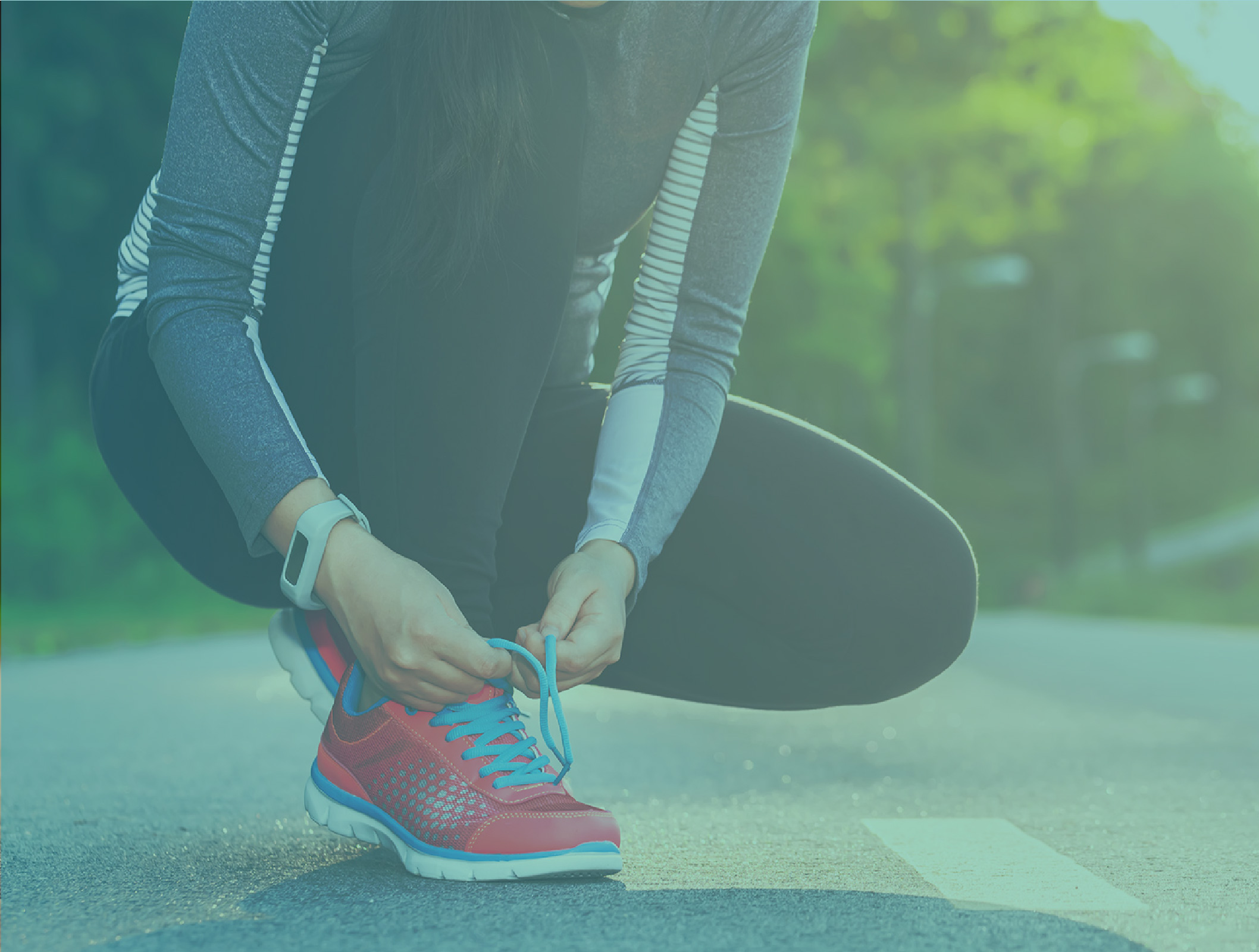 A woman is tying her running shoes outdoors